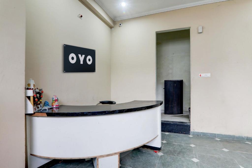 a lobby with a round table and a sign on the wall at OYO Shine Hotel in Lucknow