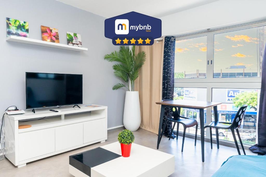 a living room with a tv and a table at Charming & Connected Studio Papeete near Cruise Terminal in Papeete
