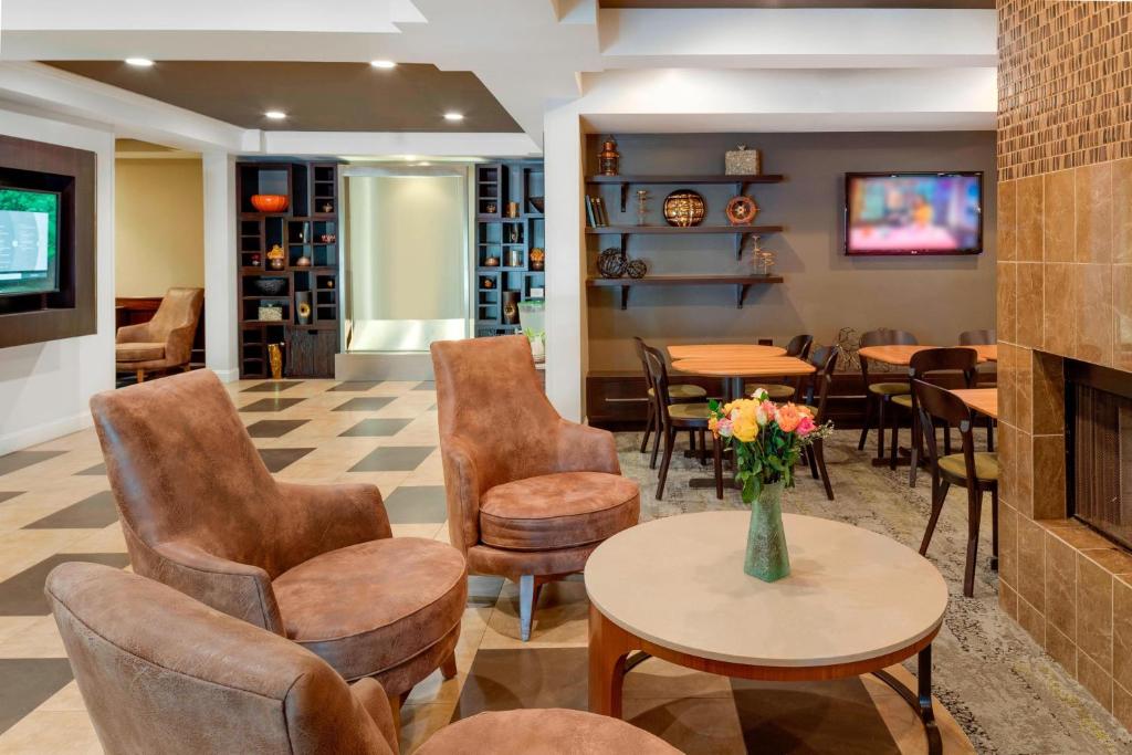 a lobby with chairs and tables and a fireplace at Courtyard by Marriott Portsmouth in Portsmouth