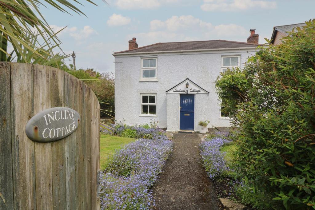 een wit huis met een blauwe deur bij Incline Cottage in Portreath