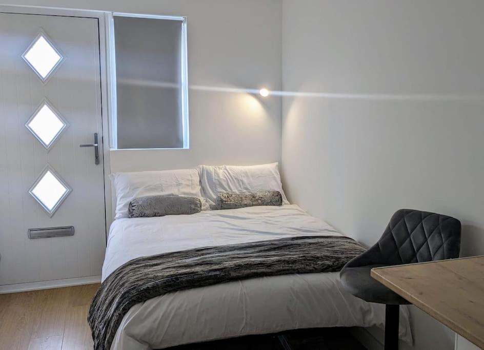 a small bed in a room with a window at Southend Airport Ground Floor Studio, with parking in Southend-on-Sea