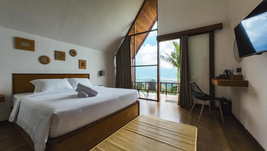 ein Schlafzimmer mit einem Bett und einem großen Fenster in der Unterkunft Catu Glamping Bedugul in Tabanan