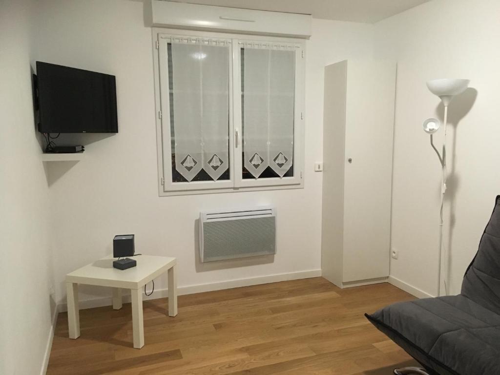 un salon avec une table et une fenêtre dans l'établissement Studio - Le Pouliguen, au Pouliguen