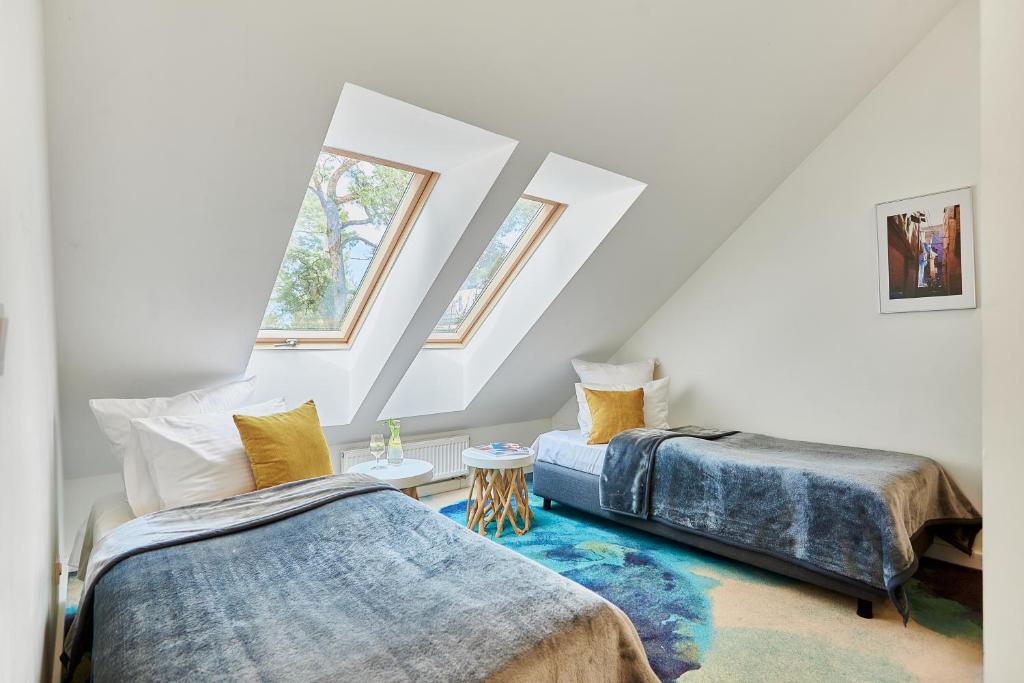 two beds in a attic room with two windows at West Baltic Resort Wellness & Spa in Świnoujście