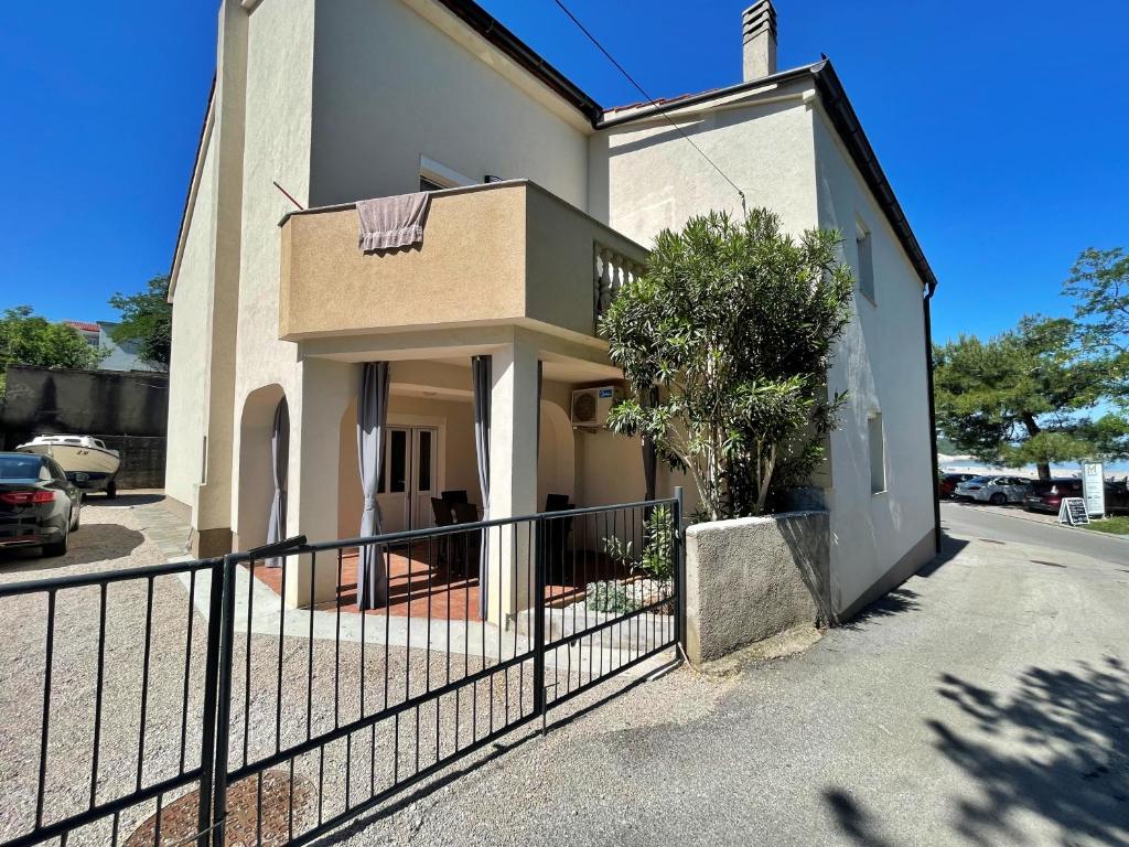 a white building with a fence in front of it at Apartment Butkovic in Šilo