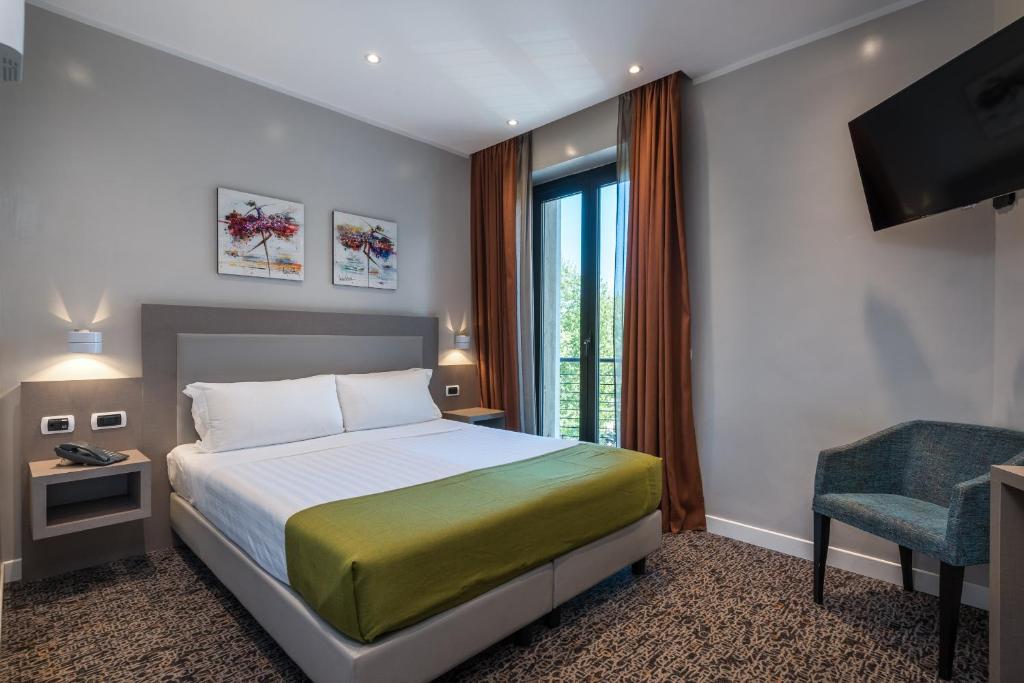 ローマにあるNoba Hotel e Residenzeのベッドとテレビが備わるホテルルームです。