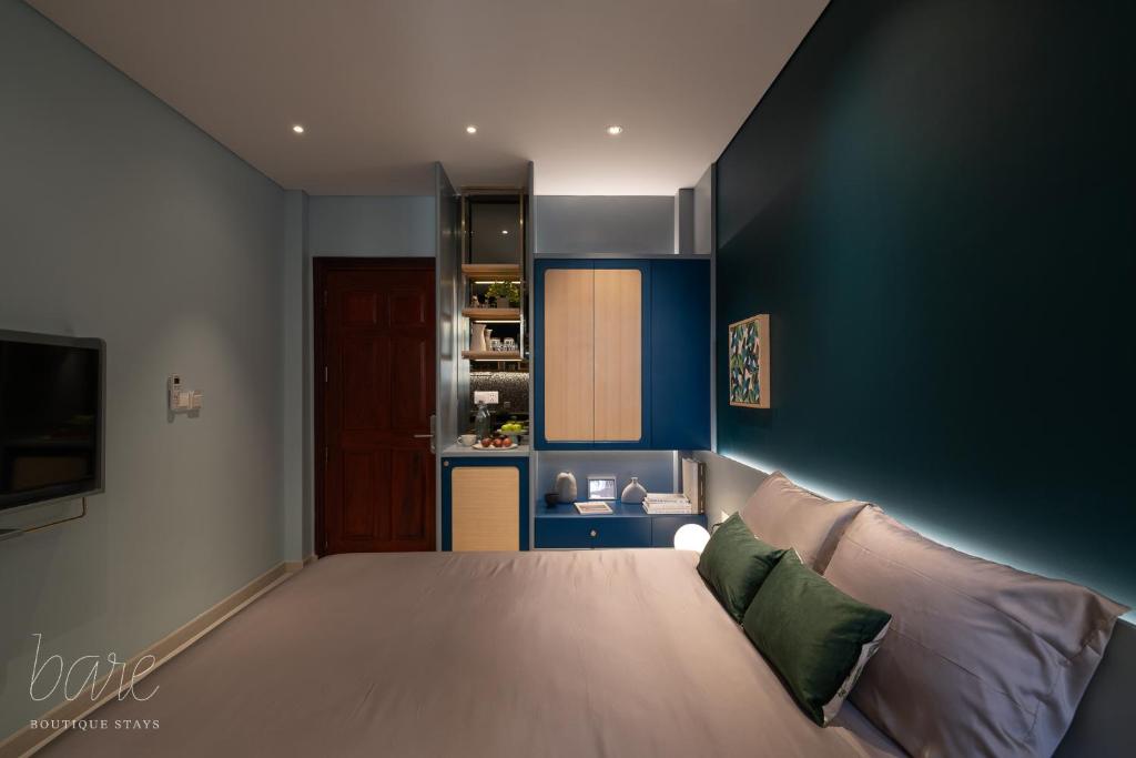 a living room with a couch and a kitchen at Bare Hyphen - Bare Boutique Stays in Ho Chi Minh City