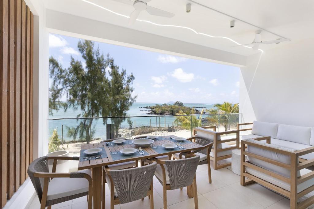 a dining room with a table and chairs and a view of the ocean at Ocean Grand Gaube in Grand Gaube