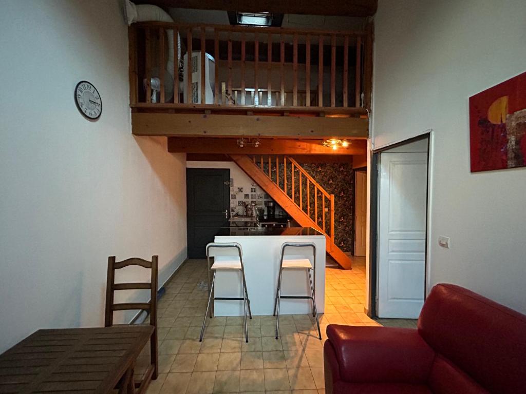 - une cuisine et un salon avec un comptoir et des tabourets dans l'établissement Appartement en plein centre face à la mairie de Balaruc-les-Bains, à Balaruc-les-Bains