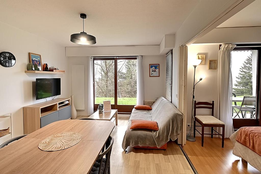 un salon avec une table et un canapé dans l'établissement Entre Lac et Montagne - Appt pour 4 - Garage privé, à Gérardmer