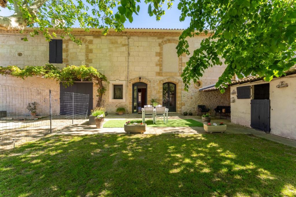 une cour d'un bâtiment avec une pelouse dans l'établissement Le Mas de Liam - Maison de plain-pied climatisée, à Comps