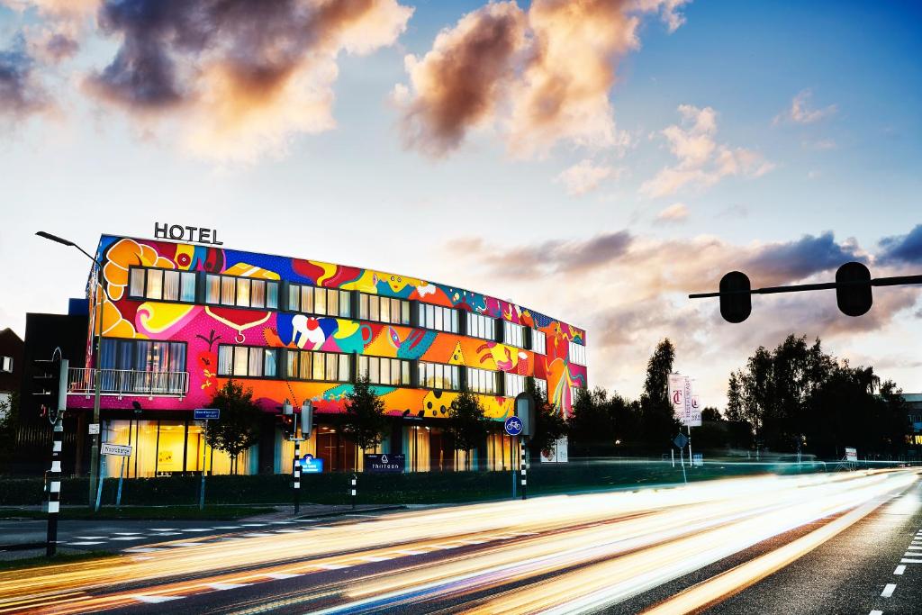 un edificio de hotel en una calle de la ciudad con un semáforo en Hotel ten Cate Emmen, en Emmen