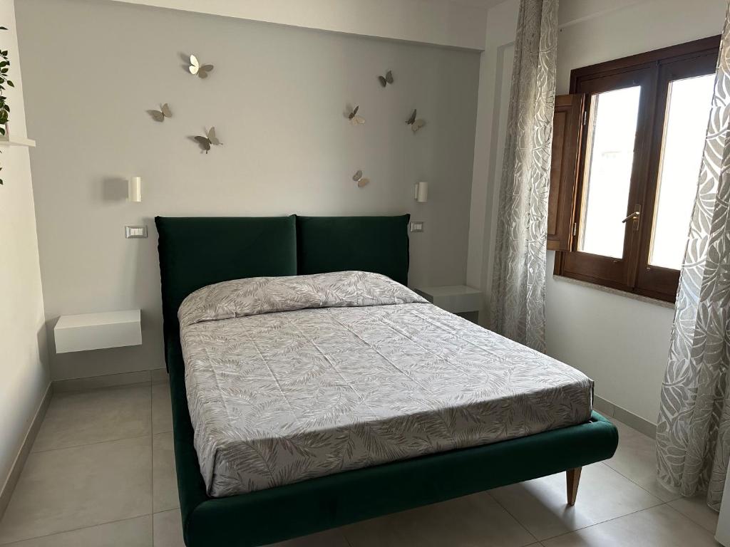 1 dormitorio con 1 cama verde en una habitación con ventana en B&B Chiedi la Luna, en San Vito lo Capo