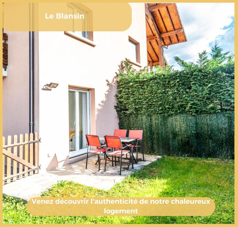 een huis met een tafel en stoelen in de tuin bij Appartement Le Blansin in Saint Pierre en Faucigny