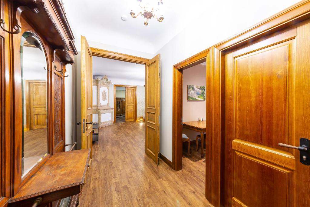 a hallway with a wooden door and a table at Just Renovated Stories Apartment Free parking in Riga