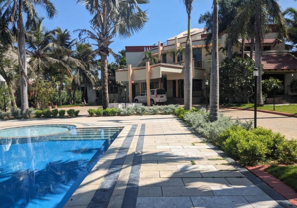 a house with a swimming pool and palm trees at Shanthi Nivaas in Chennai