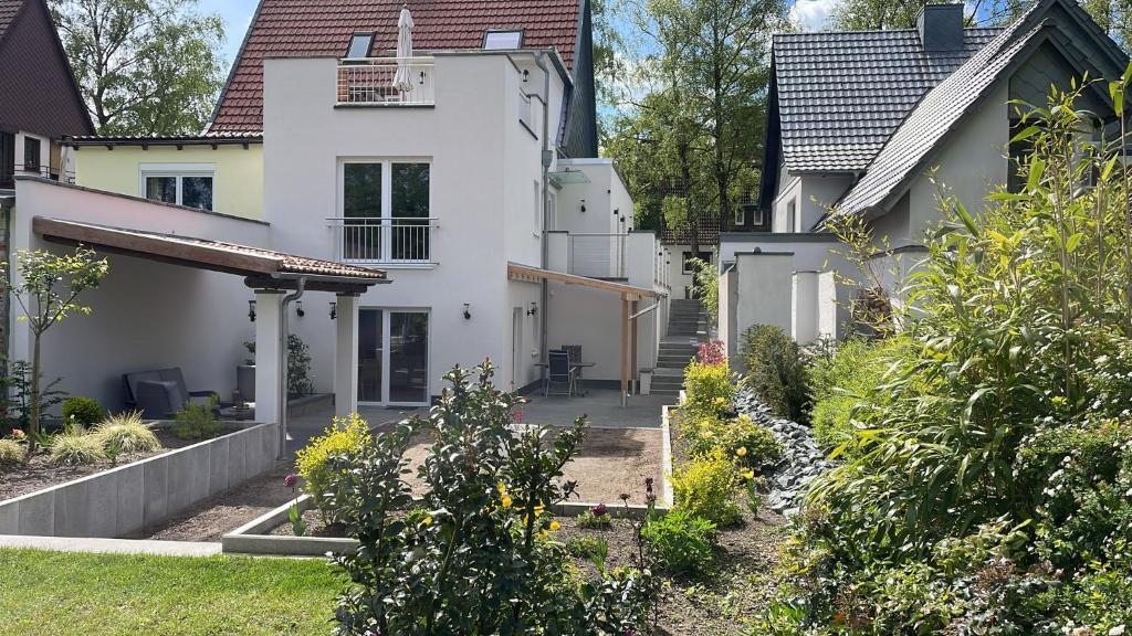uma casa branca com um jardim em frente em City Wohnung mit Gartenblick und Dachterrasse em Verden