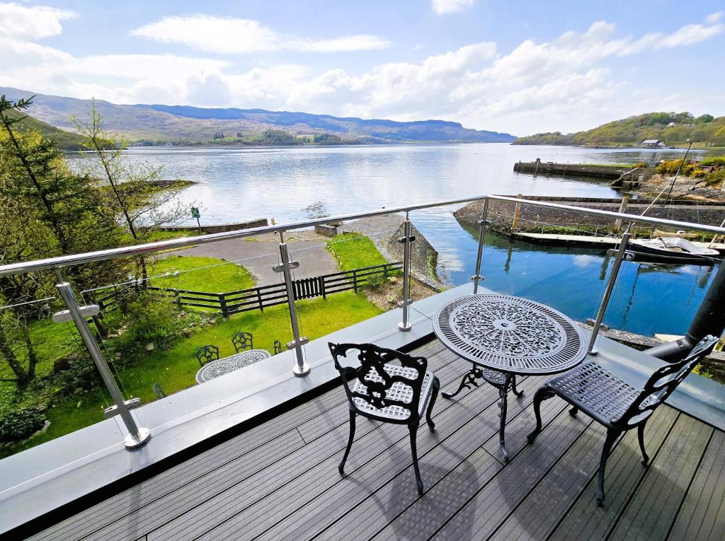 d'un balcon avec une table et des chaises et une vue sur le lac. dans l'établissement Melfort Pier & Harbour Resort, à Kilmelfort