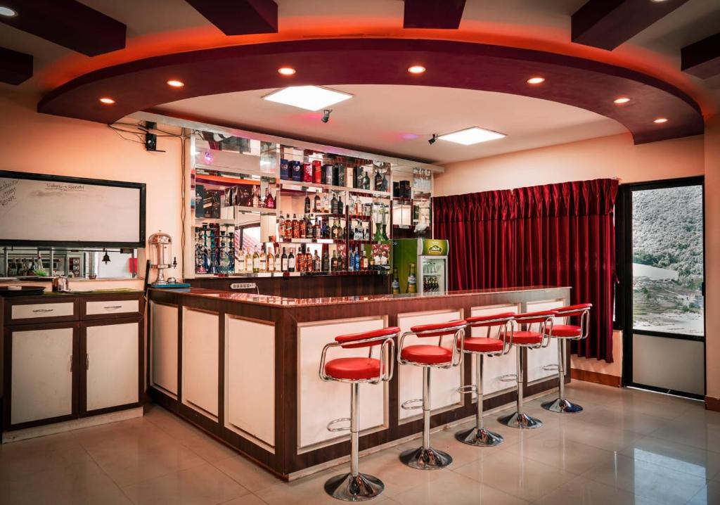 a bar with red stools in a room at Doleshwor Village Resort & Farm House Pvt. Ltd. in Bhaktapur