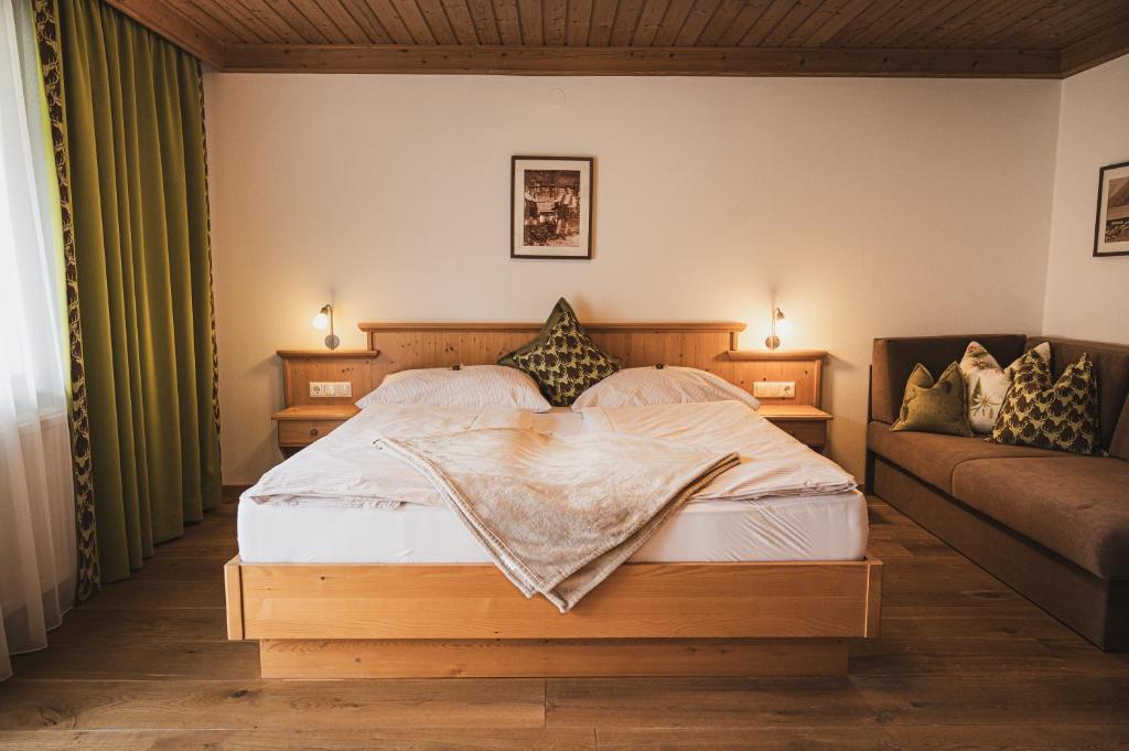 una camera da letto con un letto e un divano di Gästehaus Einödberg a Mittersill