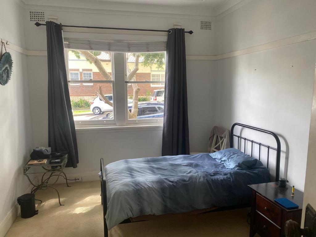 una camera con un letto di fronte a una finestra di Hilda Grange a Sydney