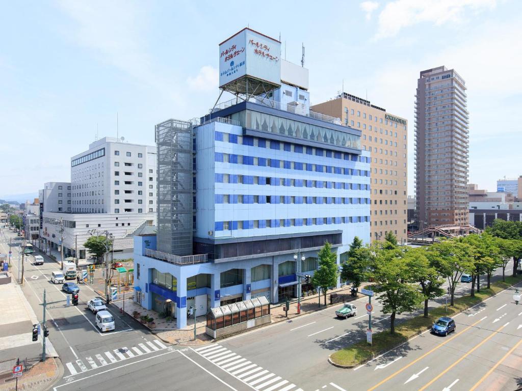 un grand bâtiment bleu avec une tour en haut dans l'établissement Hotel Pearl City Akita Kanto-Odori, à Akita