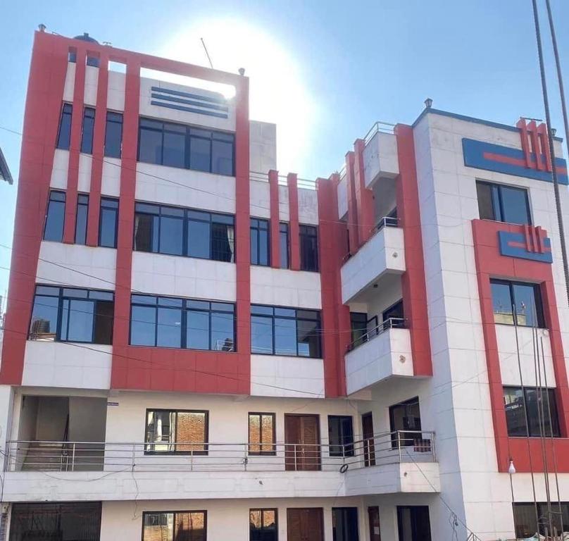 een groot gebouw met rood en wit bij Om Kedareshwar Boys Hostel in Kathmandu