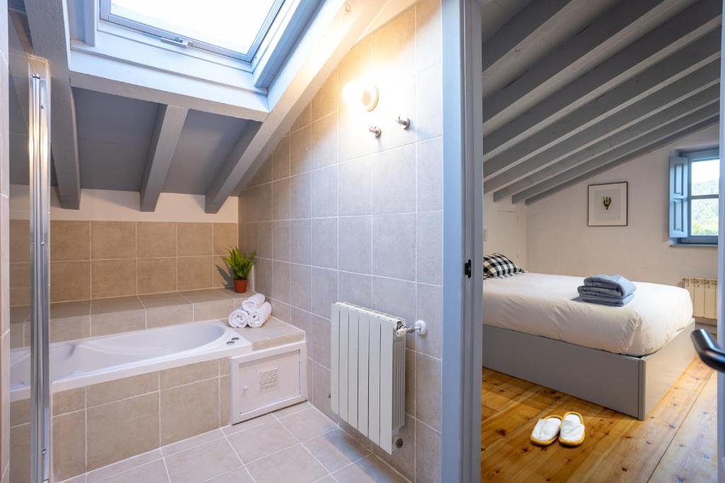 Habitación con baño con bañera y cama. en Casona Las Cinco Calderas, en Galizano