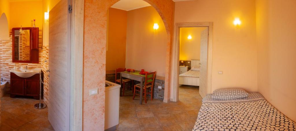 イグレージアスにあるAlba Sarda Residenceのベッド、キッチン、テーブルが備わる客室です。