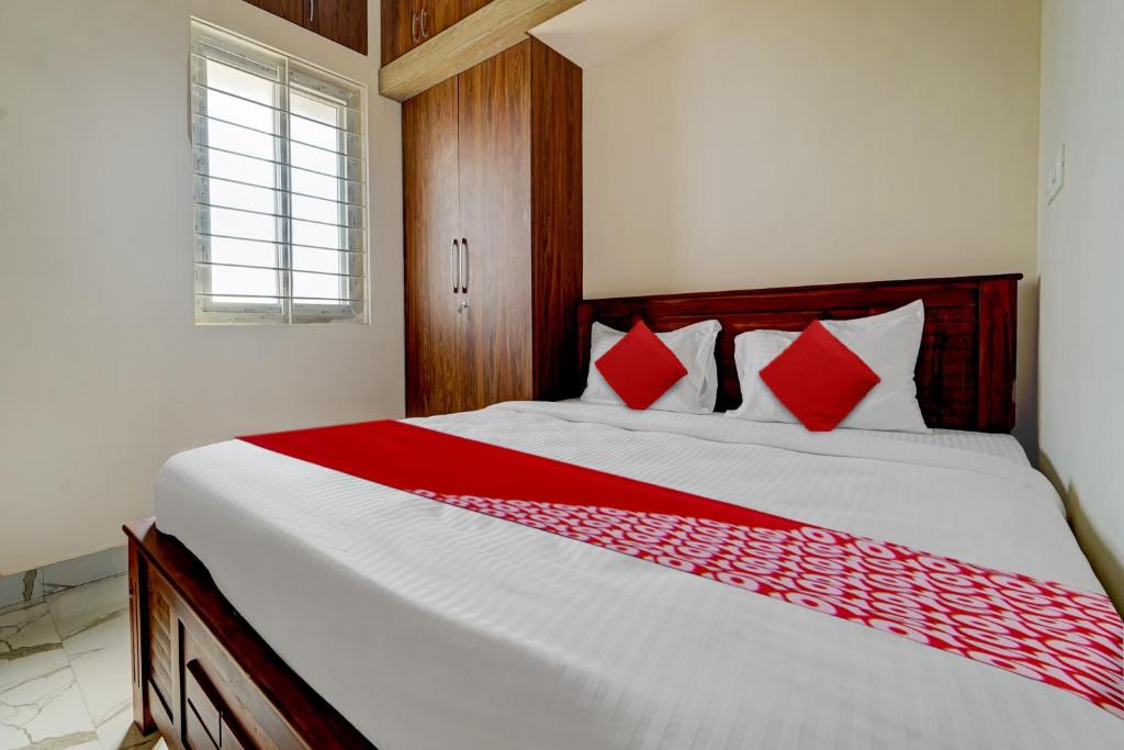 a bedroom with a large bed with red pillows at Mm Home Stays in Irugūr