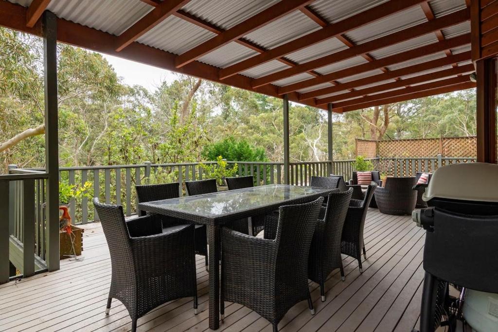 a patio with a table and chairs on a deck at Mountain Home Leura - Perfect Weekend Escape in Leura
