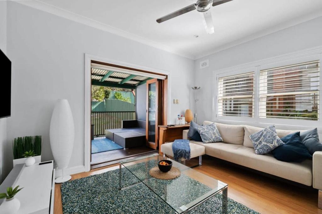 a living room with a couch and a table at Relaxed Clovelly Beach Home - Parking - Cloey6 in Sydney