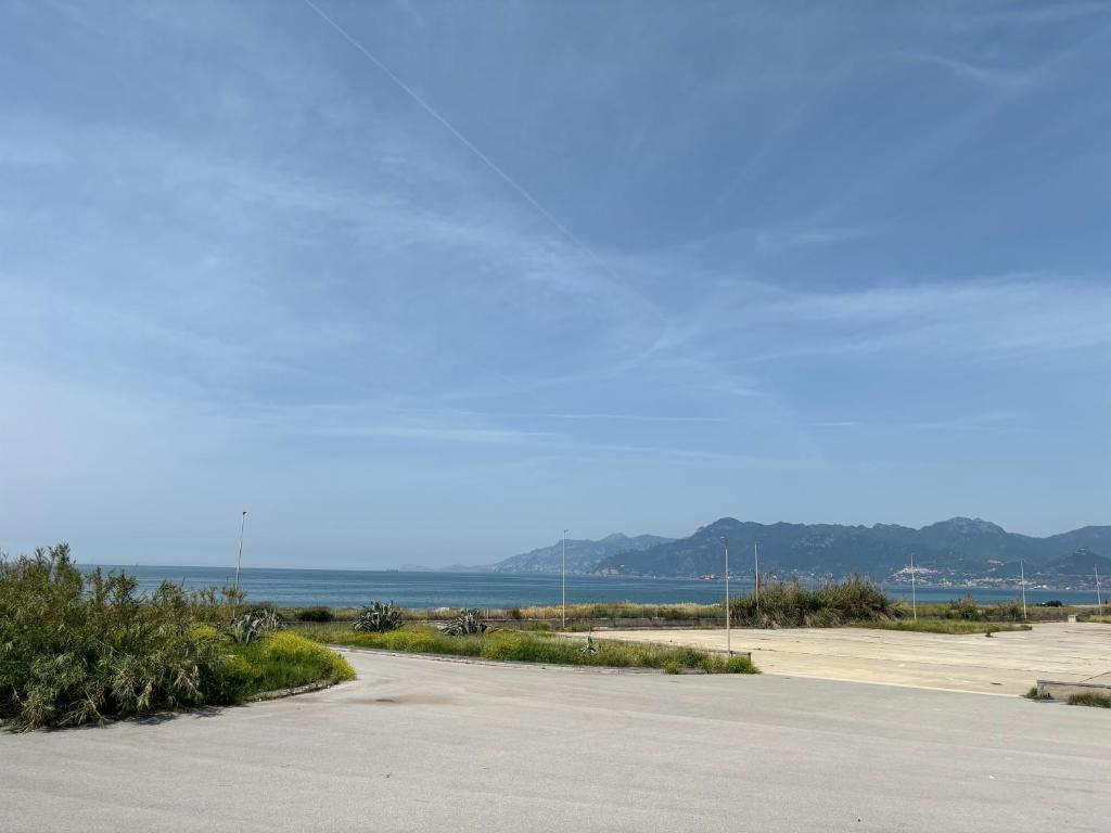 an empty road with the ocean in the background at Villetta con Giardino in Salerno