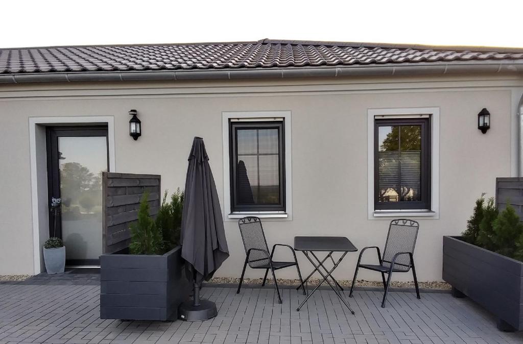 un patio con sillas, una mesa y una sombrilla en Auszeit-Räumlichkeiten, en Dietfurt