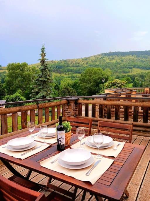 - une table en bois avec des assiettes et des verres à vin sur une terrasse dans l'établissement Casita de Dorres, à Dorres