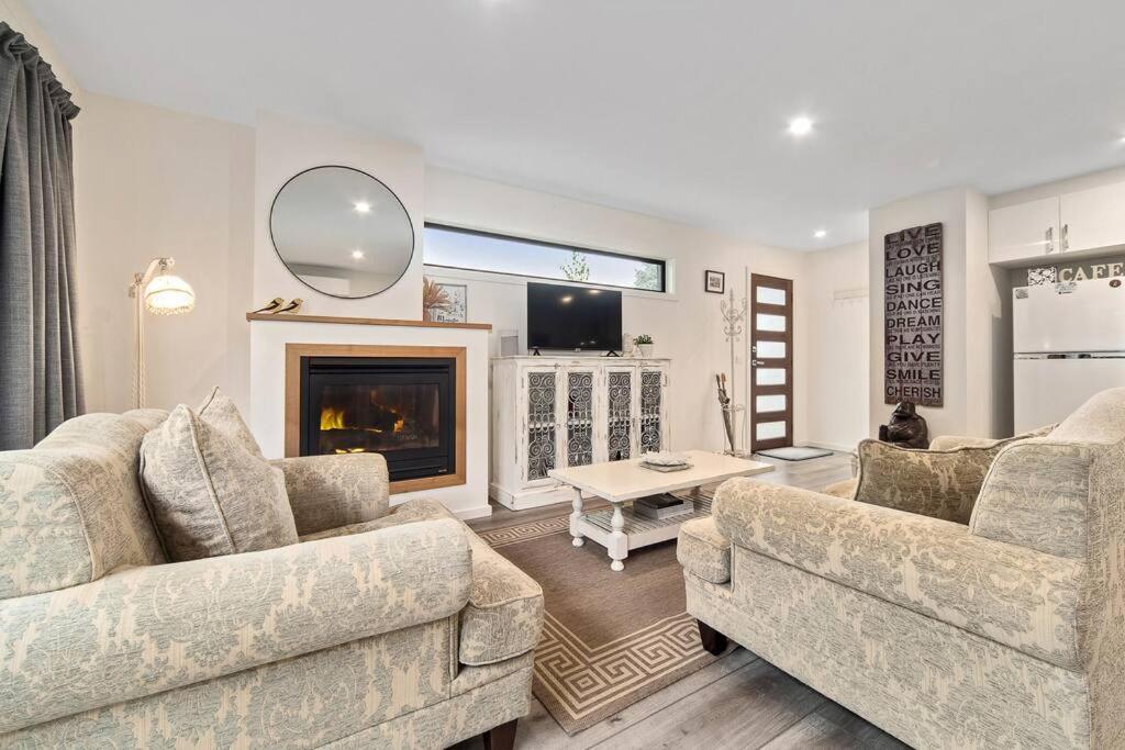 a living room with two couches and a fireplace at Joan's Beach Cottage in Mount Martha