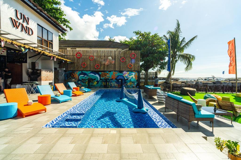 - une piscine avec des chaises et un toboggan dans un complexe dans l'établissement UNWND Boutique Hotel Camiguin, à Mambajao