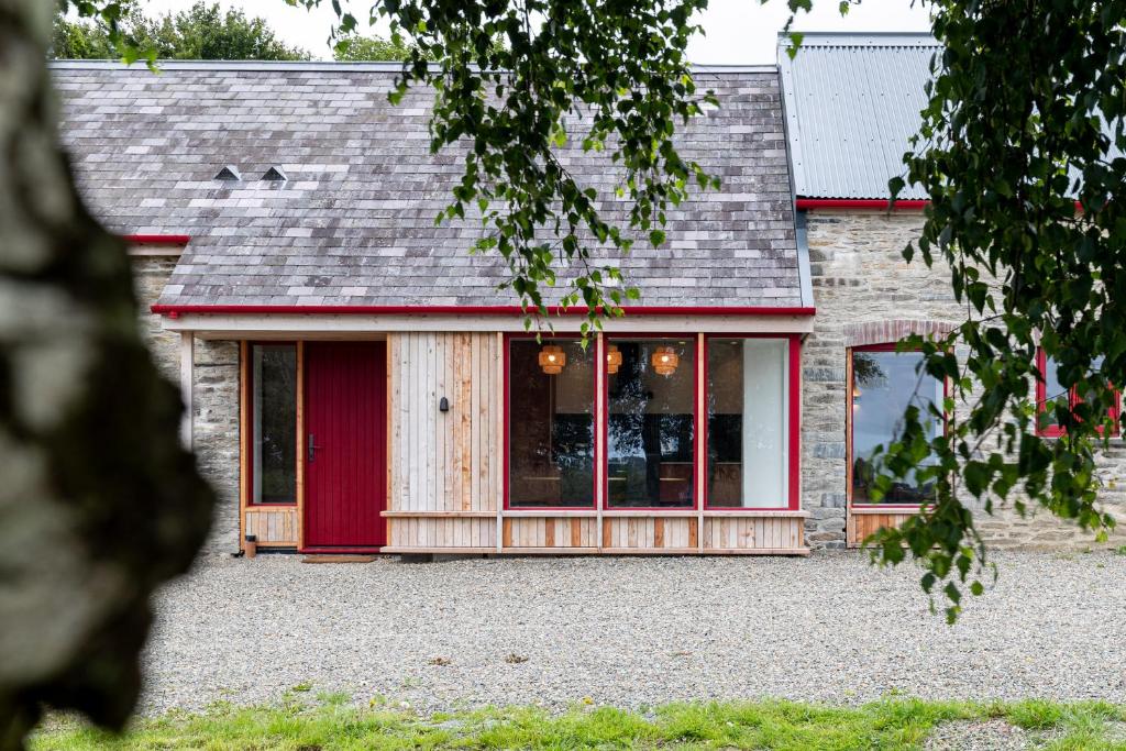 a house with red doors and a gray roof at Luxury Stargazers Barn; Close to Coast, Town and Trails in Pembrokeshire