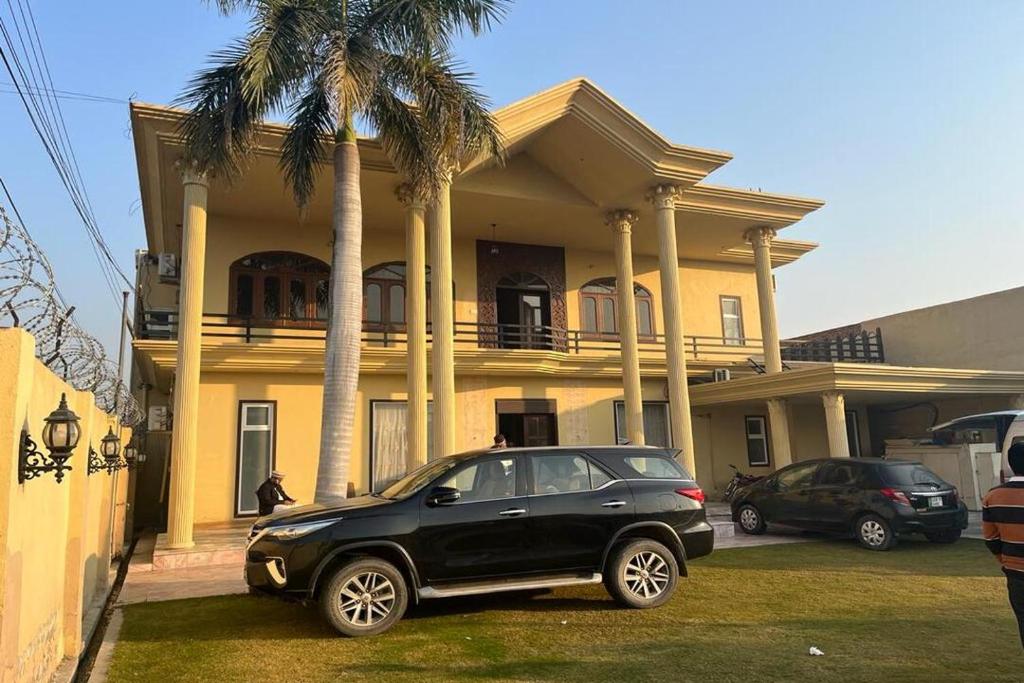 a black car parked in front of a house at Shelton Hotel Mardan in Mardan