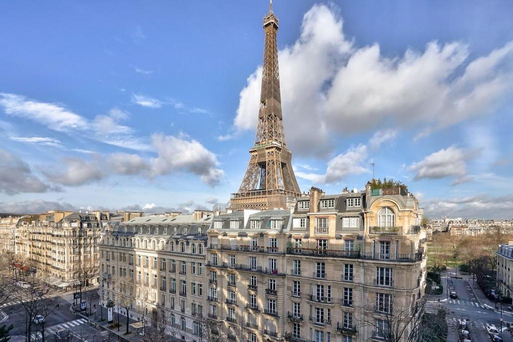 une vue de la tour Eiffel au sommet d'un immeuble dans l'établissement Magnifique appartement 80 m2 face Tour Eiffel, à Paris