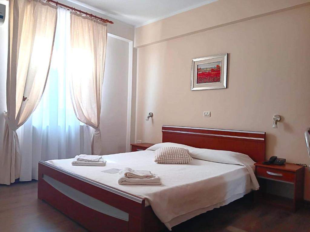 a bedroom with a bed and a window at Hotel vila veneto in Timişoara
