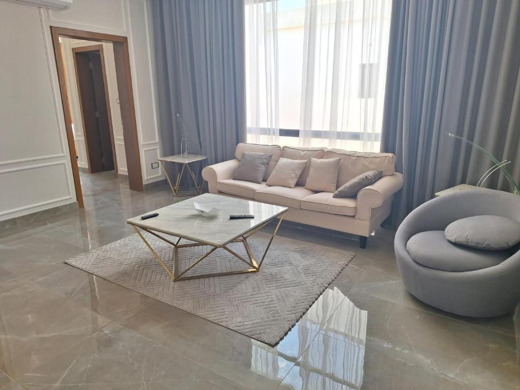 ein Wohnzimmer mit einem Sofa und einem Couchtisch in der Unterkunft luxurious villa in Al Budayyiâ€˜