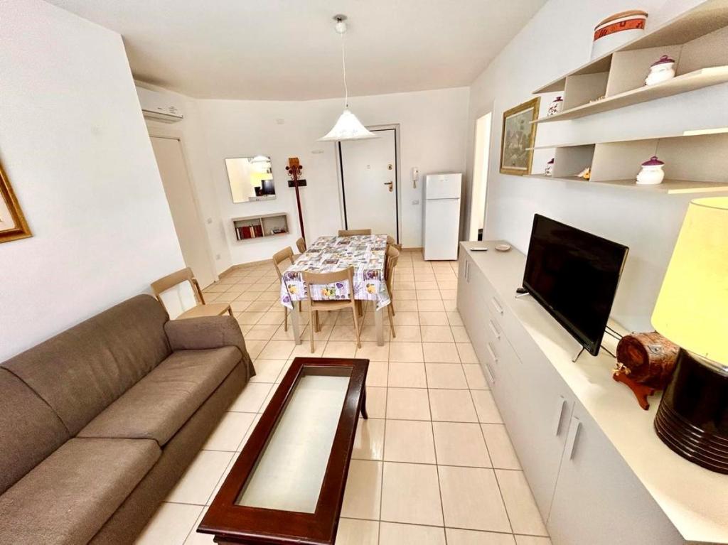 uma sala de estar com um sofá e uma mesa em RICCARDO VICINO AL MARE CON A/C em Marcelli