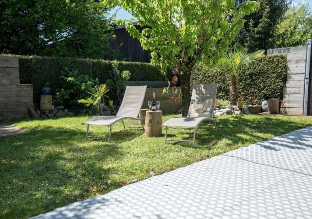 dos sillas sentadas en el césped en un patio en Appartement avec Jardin à 10 min d'Annecy, en Charvonnex