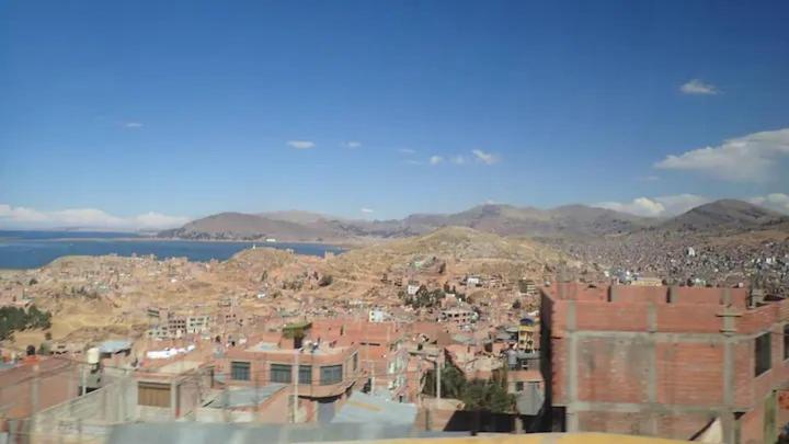 a view of a city with mountains and buildings at Apart Happy Cata in Puno