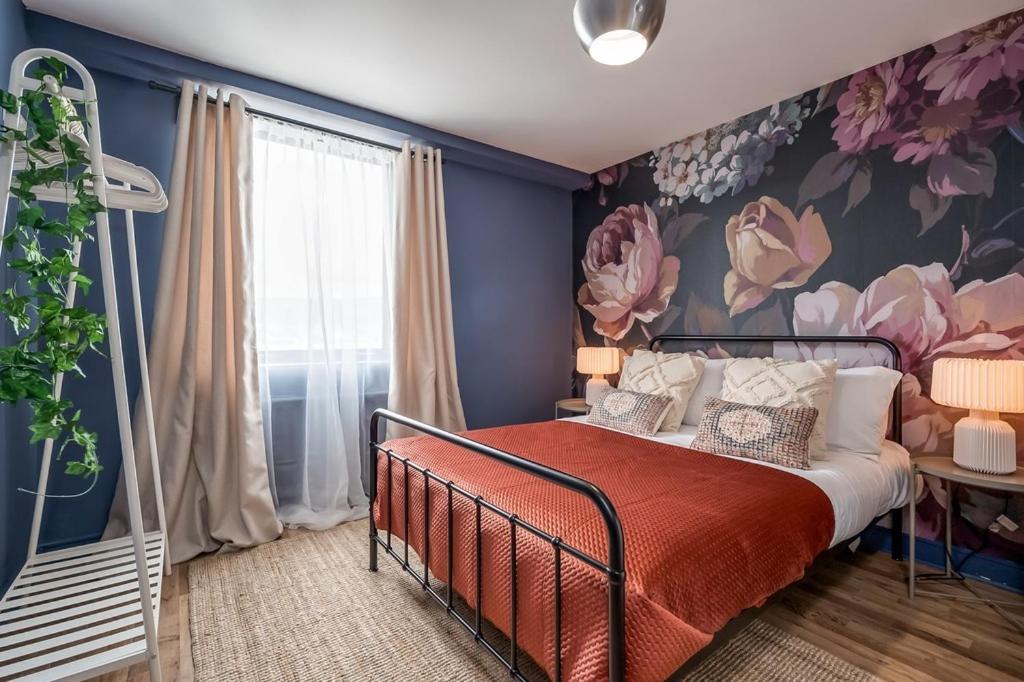 a bedroom with a bed with a floral wall at Central Belfast Apartments, Victoria Place in Belfast