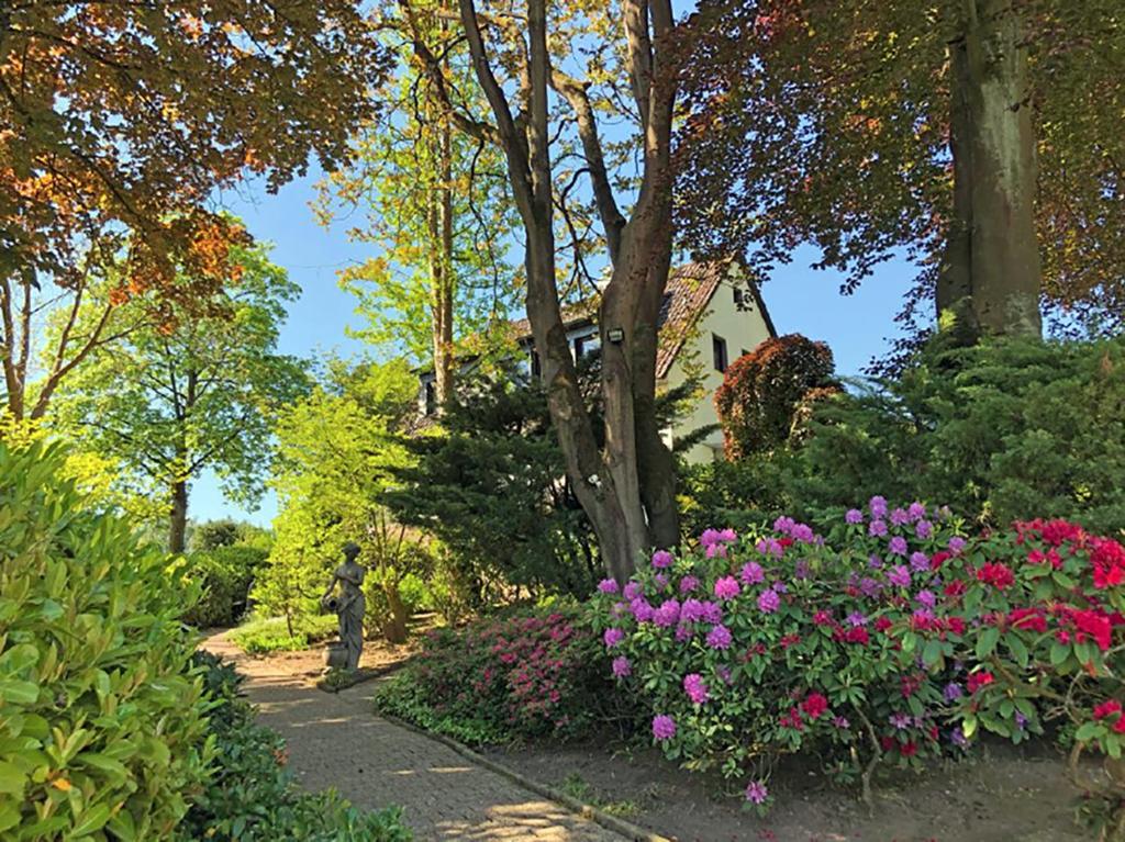 einen Garten mit Blumen und ein Haus im Hintergrund in der Unterkunft Biloba Garden 