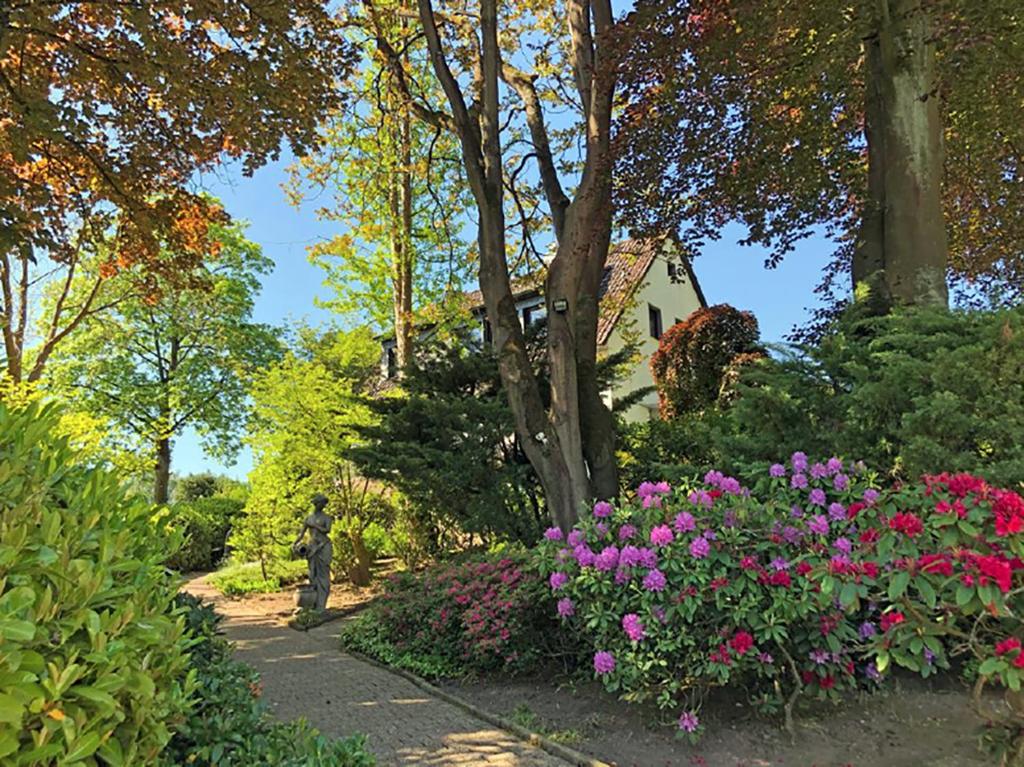 a garden with flowers and a house in the background at Biloba Garden in Wengern