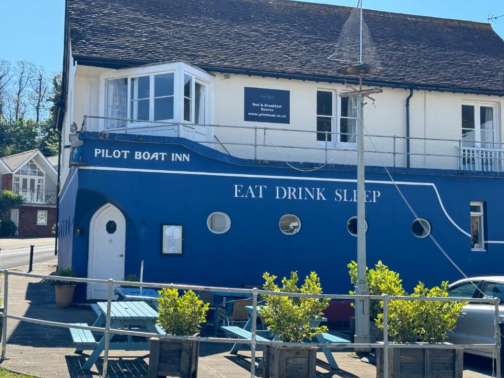 um barco azul estacionado em frente a uma casa em The Pilot Boat Inn, Isle of Wight em Bembridge