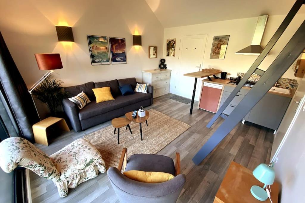 ein Wohnzimmer mit Sofa und Tisch in der Unterkunft Jolie maison pleine nature, 1-4 p, parking gratuit in La Chapelle-sur-Erdre